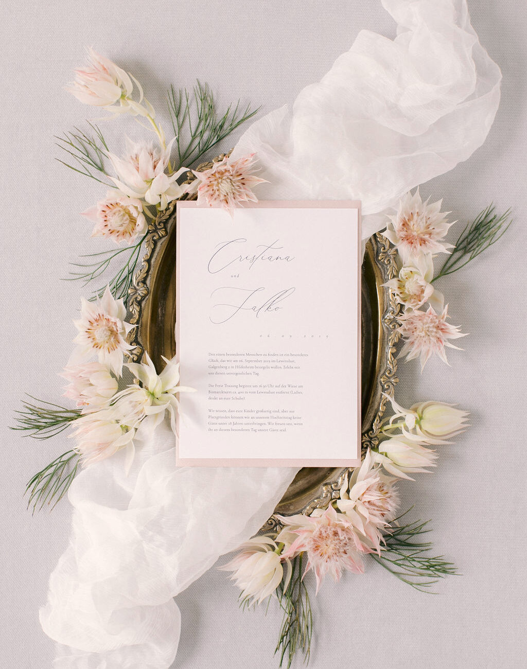 Hochzeitspapeterie: Hochzeitseinladung mit modernen Kalligrafie. Flatlay mit antikem Goldtablett mit Blumen