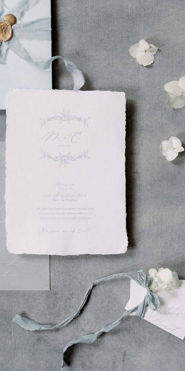 Hochzeitspapeterie: Elegante Hochzeitseinladung aus büttenpapier in hellblau und moderne Kalligrafie mit Hochzeitslogo