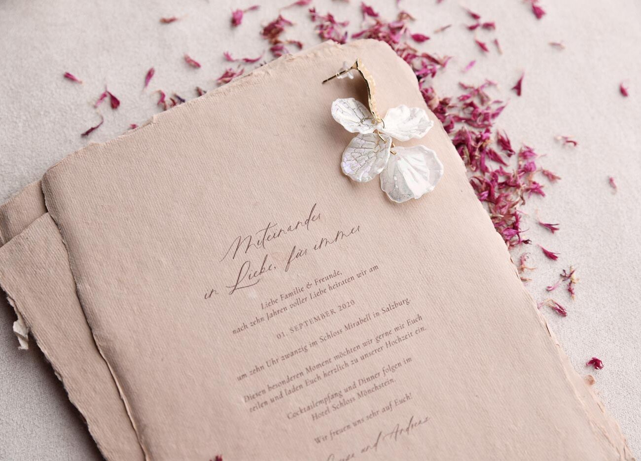 Hochzeitspapeterie: Individuelle Hochzeitseinladung aus handgerissenes Papier in Rosa, Dusty Rose, dekoriert mit Trockenblumen und getrockneten Blütenkonfetti aus roten Kornblumen