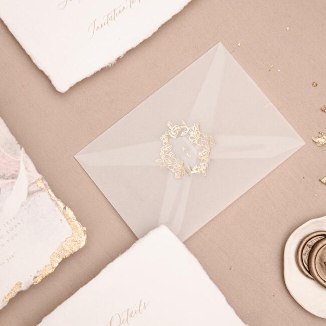 Individuelle Hochzeitspapeterie und Hochzeitseinladung mit transparent Umschlag mit Hochzeitslogo geprägt mit Heißfolienprägung in Gold