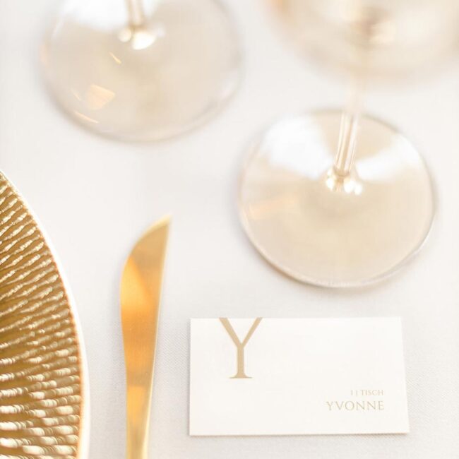Namenskärtchen mit einem individuellen und modernen Design, fotografiert auf einem Hochzeitstisch in gold und weiß