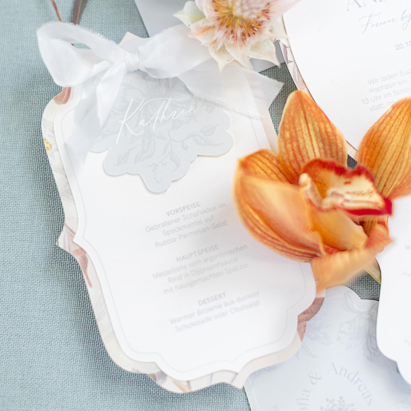 Individuelle Menükarte mit integrierter Namenskarten zusammengebunden mit einem Seidenband für eine Hochzeit im Schloss Charlottenburg