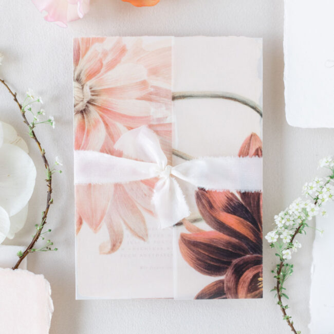 Florales Einschlagpapier mit großformatiger Blumenillustration in Rosa und Apricot, kombiniert mit einem zarten Seidenband