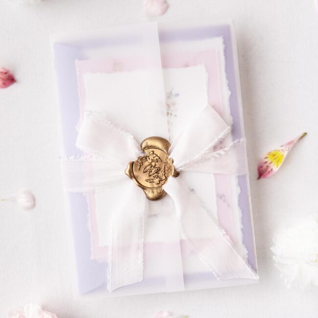 Individuelles Hochzeitseinladungsset mit transparentem Einschlagpapier, Wachssiegel und Seidenband in flieder und rosa