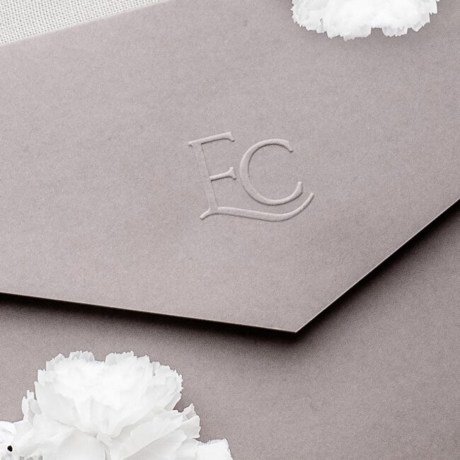 Hochzeitslogo in erhabener Blindprägung auf einem taupefarbenen Pocketfolder