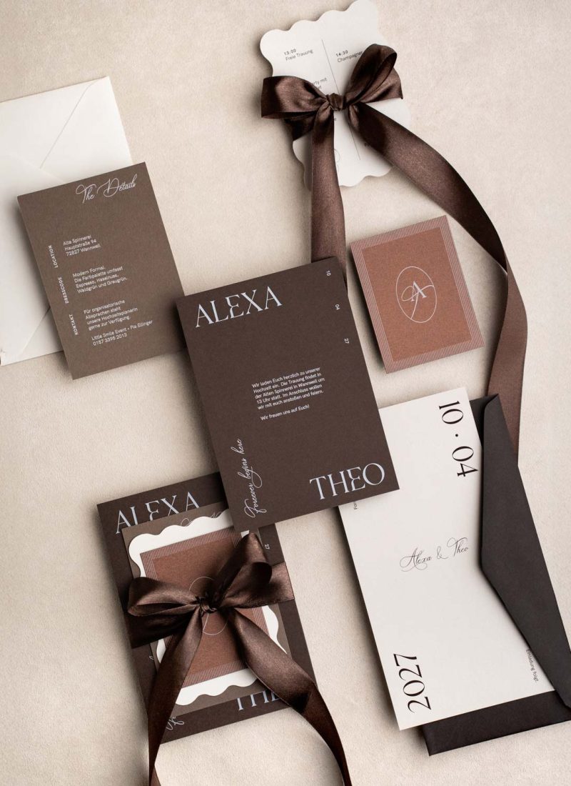 Braune moderne Hochzeitseinladung mit Weißdruck und mehreren Zusatzkarten als Flatlay