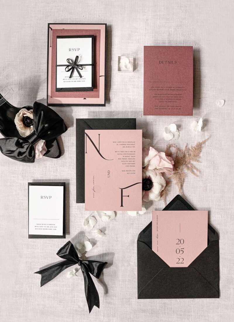 vorgefertigte Hochzeitspapeterie Flatlay von moderne Einladungskarte, Save The Date Karte in Dusty Pink Altrosa mit schwarzen Briefumschlägen